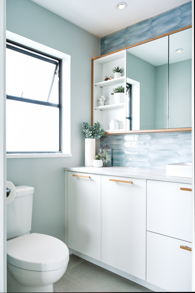Inspiration for a mid-sized contemporary master bathroom in Vancouver with flat-panel cabinets, white cabinets, an alcove shower, a two-piece toilet, blue tile, porcelain tile, grey walls, a vessel sink, engineered quartz benchtops, grey floor, grey benchtops, a single vanity and a built-in vanity.