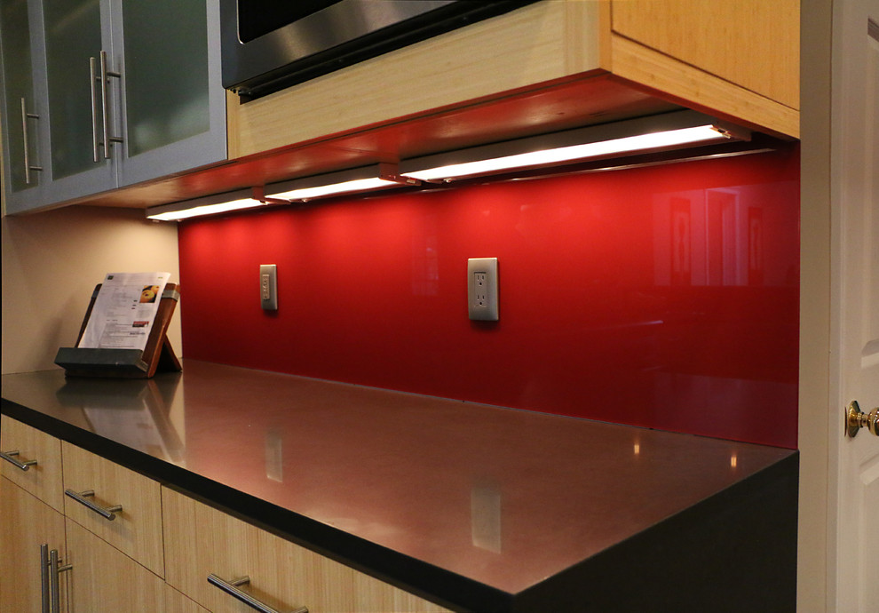 This is an example of a mid-sized contemporary u-shaped eat-in kitchen in Bridgeport with flat-panel cabinets, light wood cabinets, red splashback, stainless steel appliances, no island, a farmhouse sink and quartz benchtops.