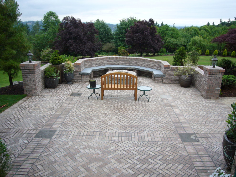 Traditional backyard patio in Portland with brick pavers.