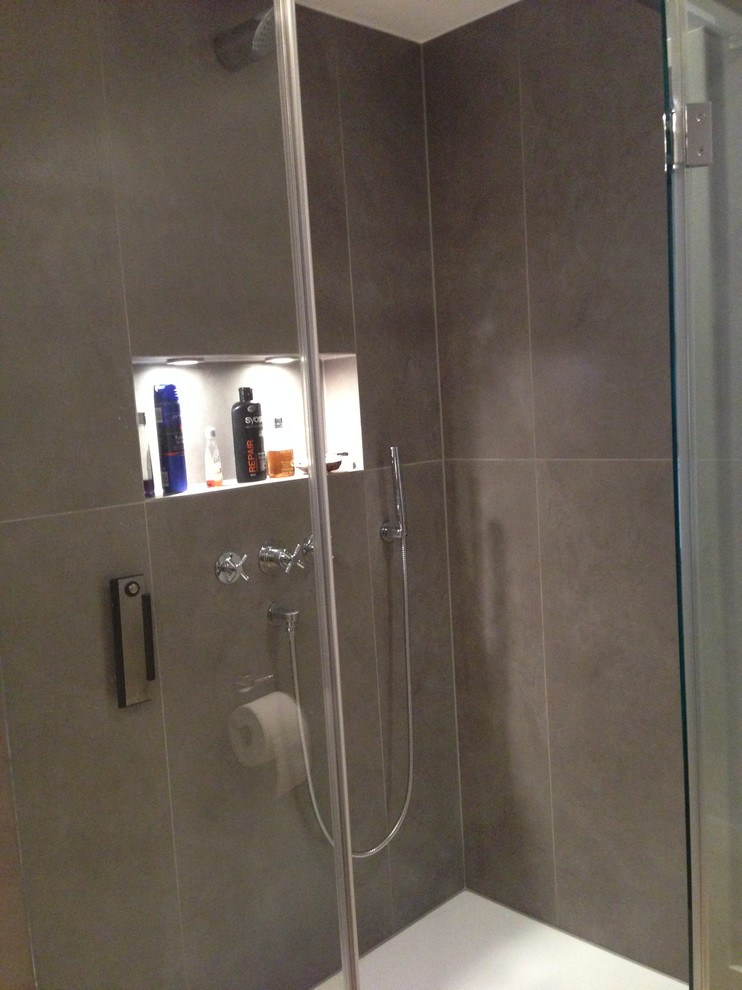 Idee per una piccola stanza da bagno minimal con doccia a filo pavimento, WC sospeso, piastrelle nere, piastrelle in ceramica, pareti nere e pavimento in bambù