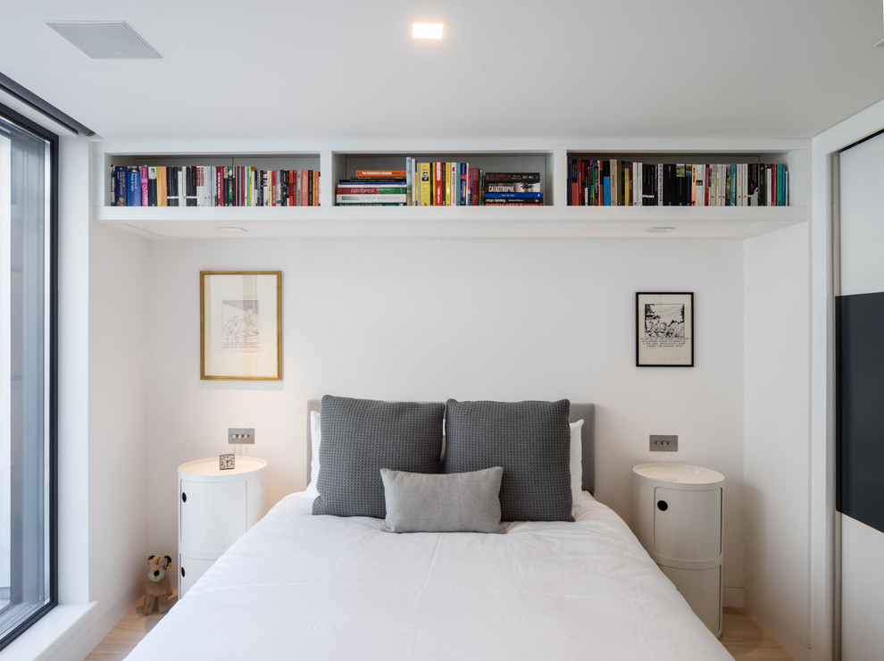 Photo of a small contemporary bedroom in London with white walls, light hardwood floors and beige floor.