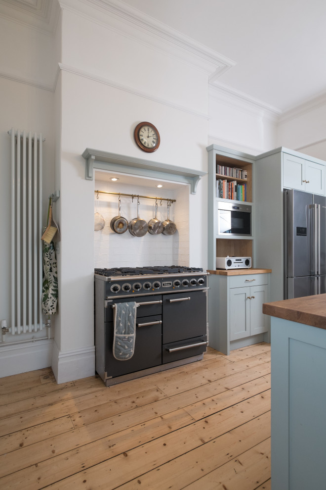 Foto di una grande cucina classica con ante in stile shaker, ante blu, top in quarzite, elettrodomestici in acciaio inossidabile, parquet chiaro e top bianco