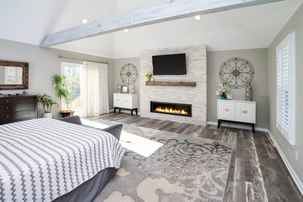 Design ideas for a transitional bedroom in Philadelphia with grey walls, medium hardwood floors, a ribbon fireplace, a stone fireplace surround and grey floor.