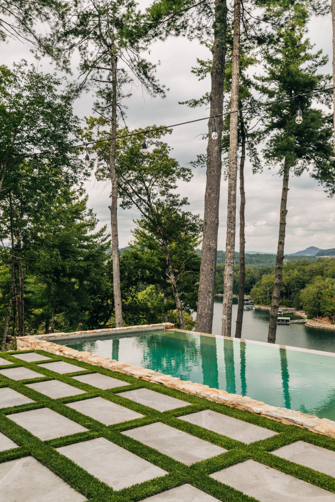 Pool - mid-sized rustic backyard rectangular and stone infinity pool idea