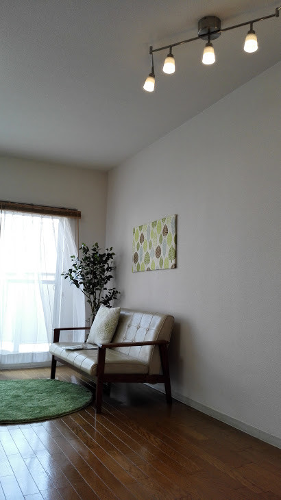 他の地域にある低価格の中くらいな北欧スタイルのおしゃれなLDK (白い壁、合板フローリング、暖炉なし、テレビなし、茶色い床) の写真