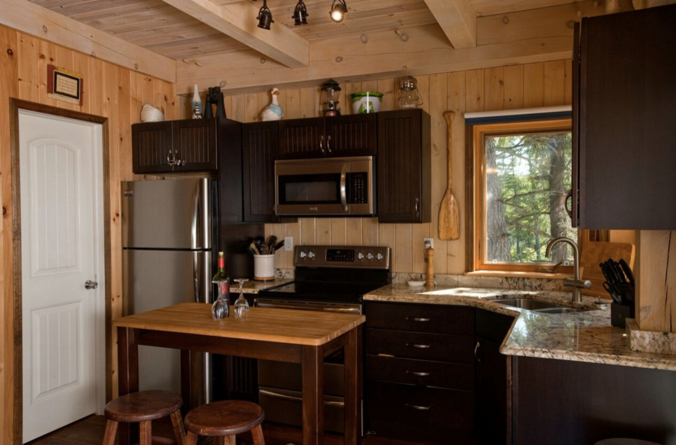 Inspiration for a large country galley open plan kitchen in Boston with an undermount sink, shaker cabinets, dark wood cabinets, granite benchtops, stainless steel appliances, light hardwood floors and with island.