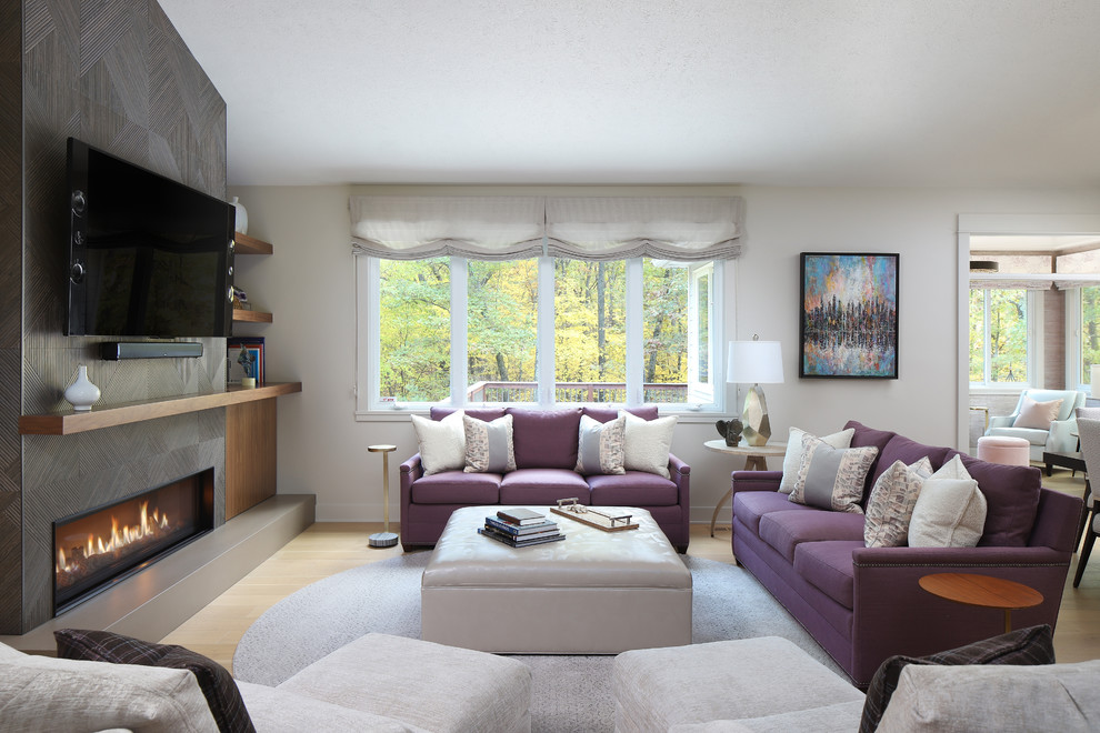 This is an example of a mid-sized contemporary open concept living room in Grand Rapids with grey walls, light hardwood floors, a ribbon fireplace, a tile fireplace surround, no tv and multi-coloured floor.