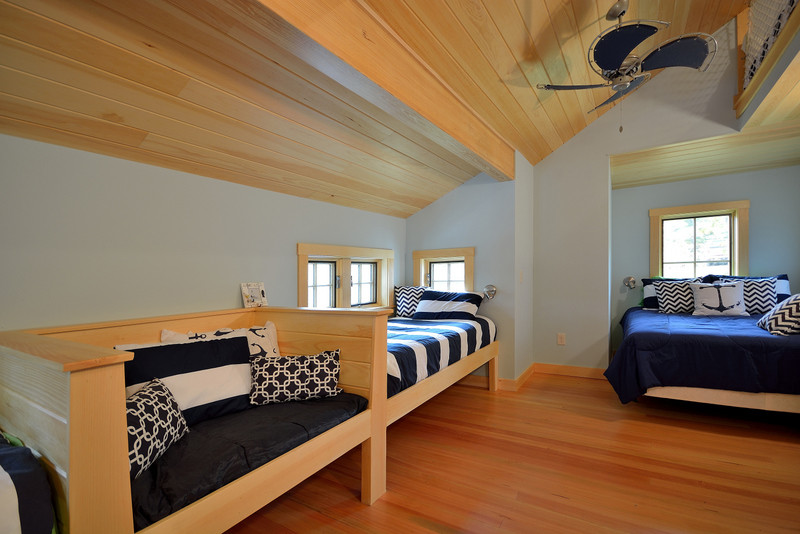 Mid-sized beach style loft-style bedroom in Portland Maine with light hardwood floors and no fireplace.