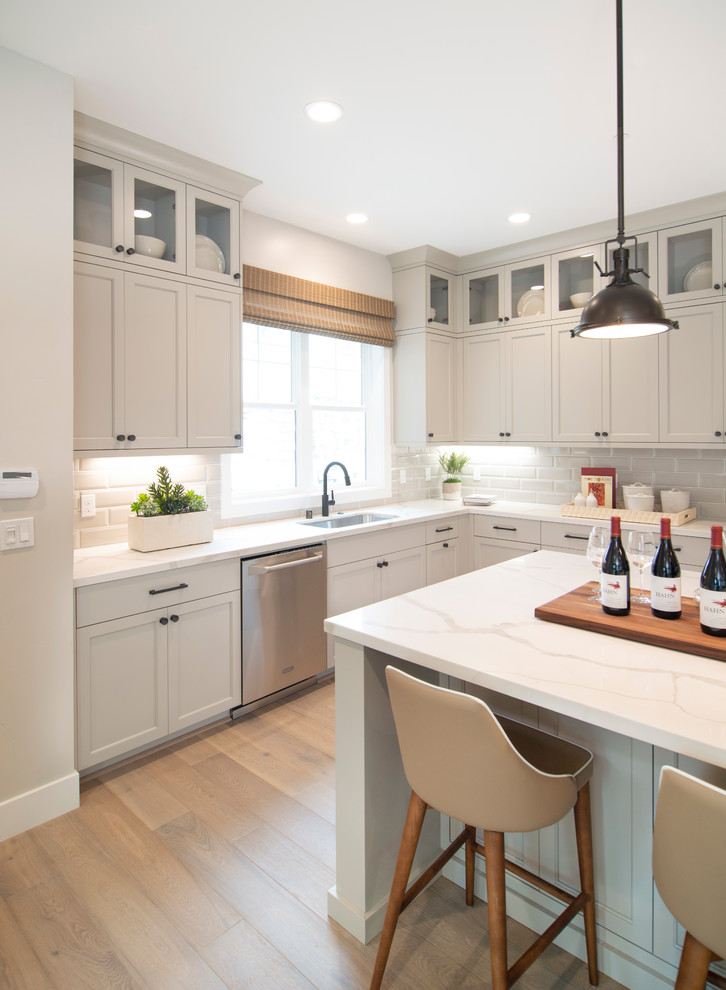 This is an example of a transitional l-shaped kitchen in San Francisco with recessed-panel cabinets and grey cabinets.