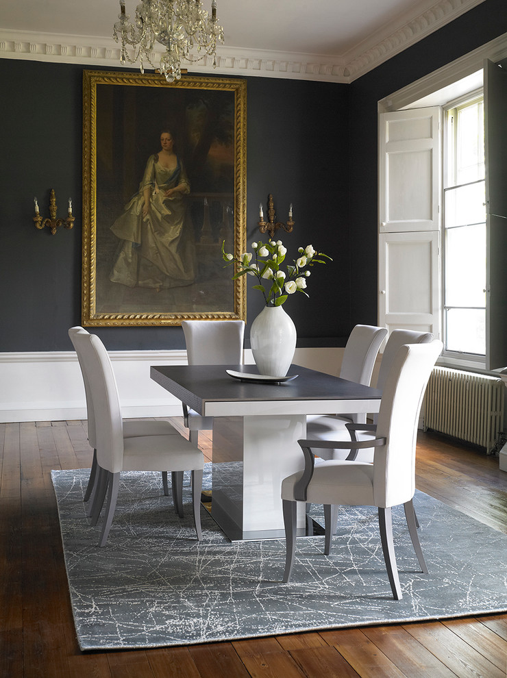 Traditional dining room in Hertfordshire with medium hardwood floors and black walls.