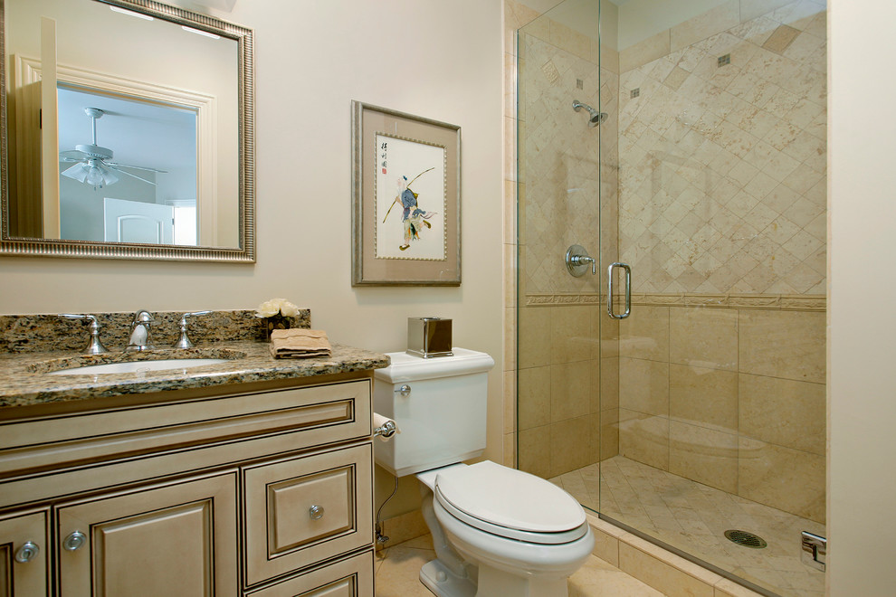 Photo of a traditional bathroom in Denver with raised-panel cabinets, beige cabinets, marble benchtops, a two-piece toilet, yellow tile, stone tile and beige walls.