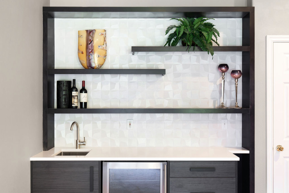 Small modern single-wall wet bar in Seattle with a built-in sink, flat-panel cabinets, dark wood cabinets, engineered stone countertops, white splashback, porcelain splashback, carpet and white worktops.