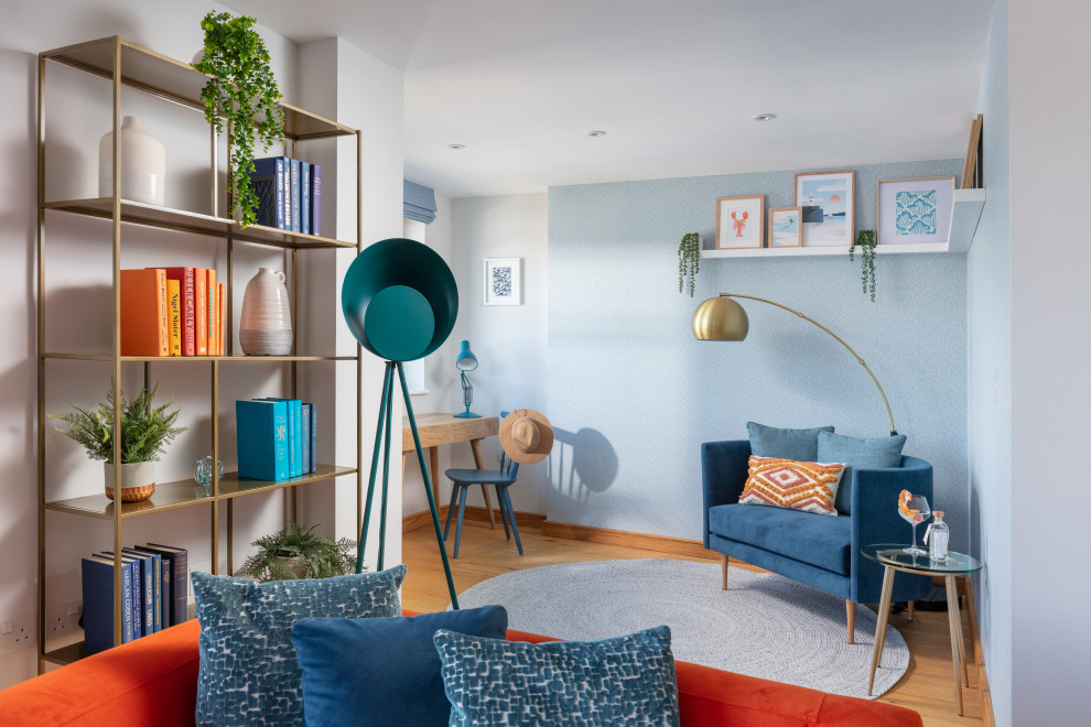 Mittelgroßes Maritimes Lesezimmer ohne Kamin mit blauer Wandfarbe, braunem Holzboden, freistehendem Schreibtisch, orangem Boden und Tapetenwänden in Cornwall