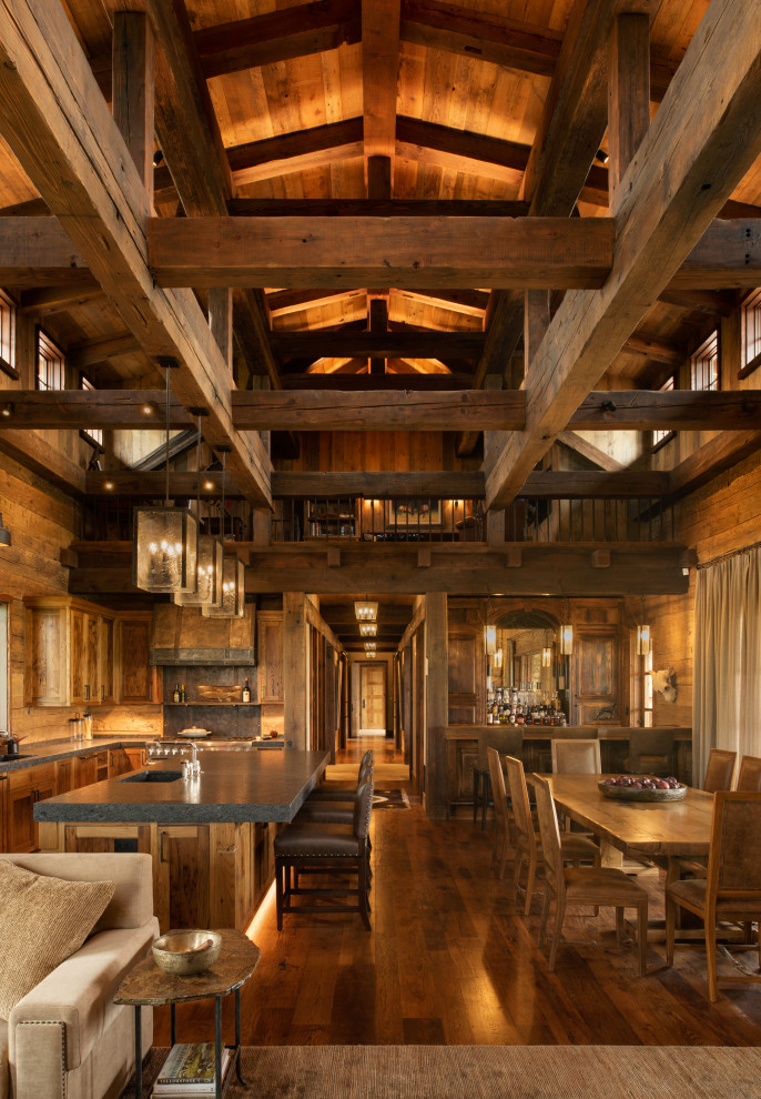Inspiration for a large rustic dark wood floor, exposed beam and wood wall great room remodel