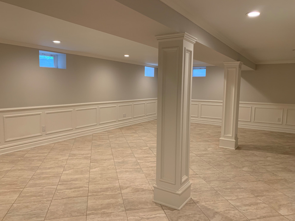 Photo of a large traditional basement in New York with grey walls, ceramic floors and beige floor.