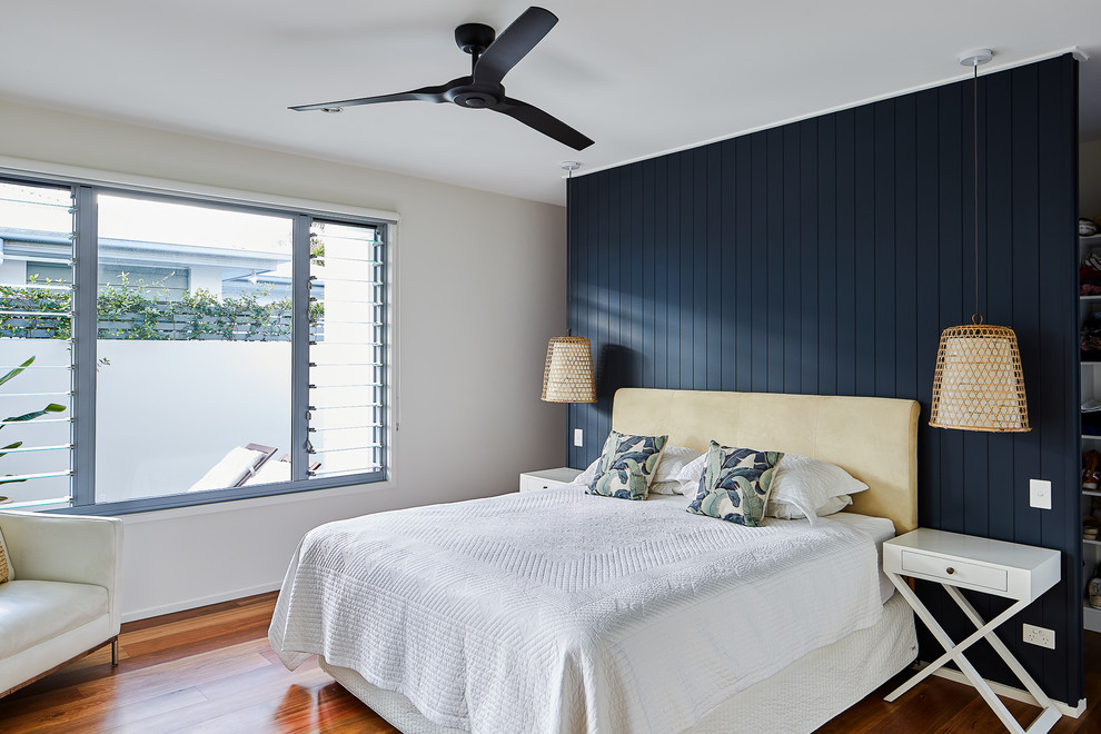 Inspiration for a beach style master bedroom in Gold Coast - Tweed with beige walls, dark hardwood floors and brown floor.