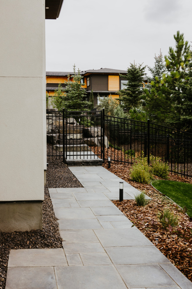 Idee per un grande privacy in giardino design esposto in pieno sole dietro casa in estate con pavimentazioni in pietra naturale e recinzione in metallo