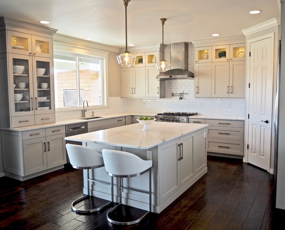Large transitional u-shaped dark wood floor kitchen photo in Denver with an undermount sink, shaker cabinets, gray cabinets, quartzite countertops, white backsplash, porcelain backsplash, stainless steel appliances and an island