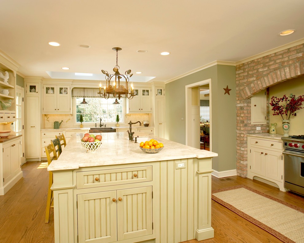 Inspiration for a large traditional u-shaped separate kitchen in Charlotte with an undermount sink, shaker cabinets, beige cabinets, beige splashback, stainless steel appliances, granite benchtops, light hardwood floors and with island.