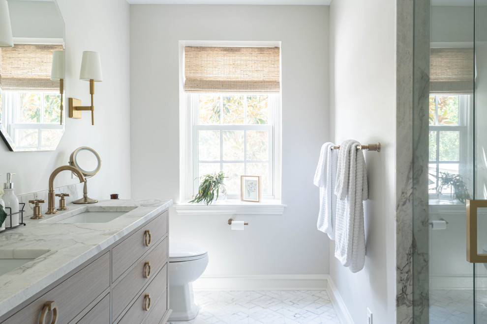 Inspiration for a medium sized traditional ensuite bathroom in Philadelphia with flat-panel cabinets, brown cabinets, an alcove shower, a one-piece toilet, marble tiles, marble flooring, a submerged sink, marble worktops, white floors, a hinged door, white worktops, a wall niche, double sinks and a freestanding vanity unit.
