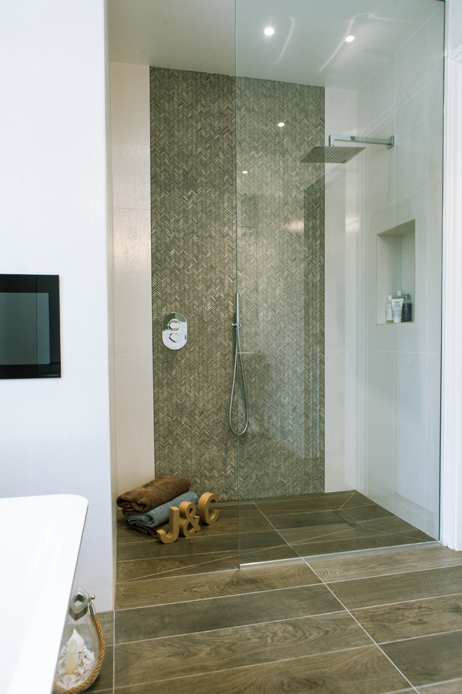 This is an example of a contemporary bathroom in London with a curbless shower, brown tile, matchstick tile, white walls and an open shower.