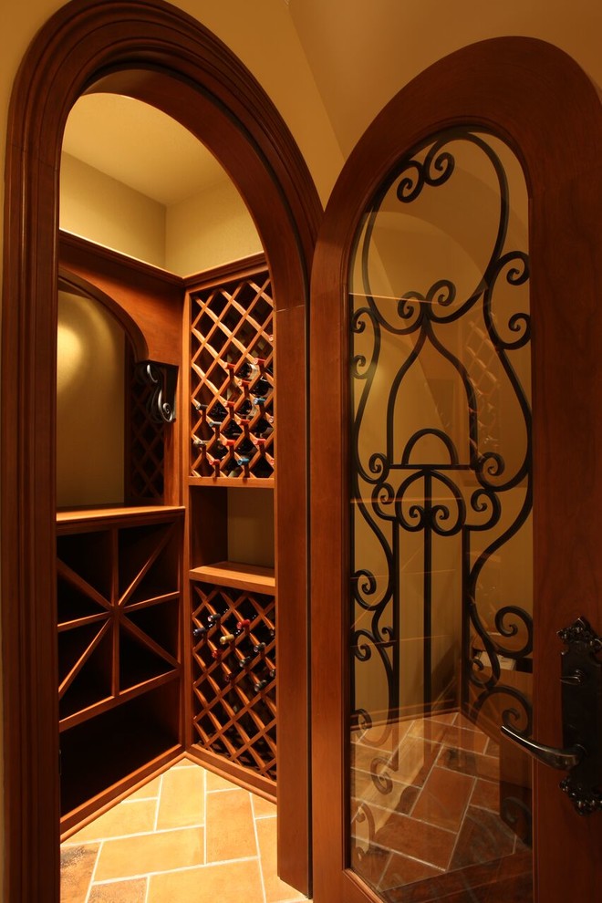 Mid-sized arts and crafts wine cellar in Other with storage racks, terra-cotta floors and yellow floor.