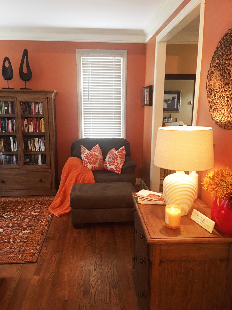 Design ideas for a small contemporary study room in Atlanta with orange walls, dark hardwood floors, a freestanding desk and brown floor.