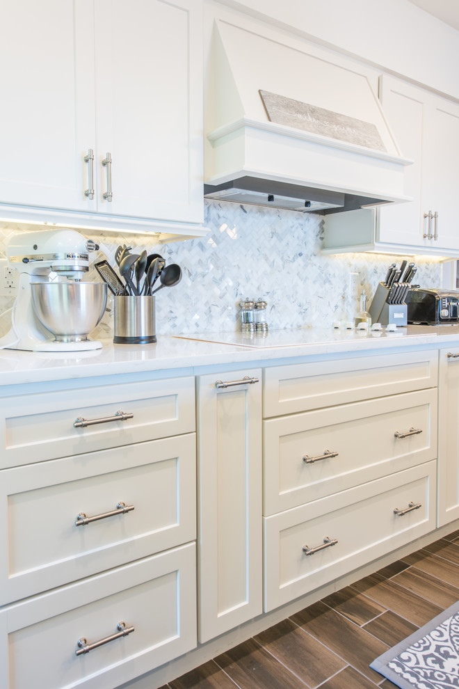 Eat-in kitchen - large transitional u-shaped porcelain tile and brown floor eat-in kitchen idea with an undermount sink, shaker cabinets, white cabinets, quartz countertops, white backsplash, marble backsplash, stainless steel appliances and two islands