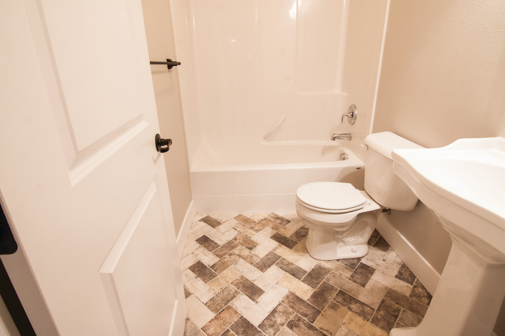 Design ideas for a small traditional kids bathroom in Other with a drop-in tub, a shower/bathtub combo, a two-piece toilet, beige walls, ceramic floors, a pedestal sink, brown floor and a shower curtain.
