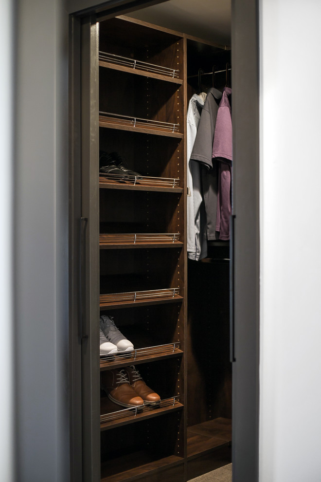 Design ideas for a small modern men's walk-in wardrobe in Milwaukee with flat-panel cabinets, medium wood cabinets, carpet and grey floor.