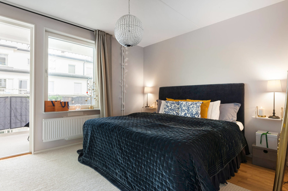 This is an example of a scandinavian bedroom in Stockholm with grey walls, medium hardwood floors and brown floor.