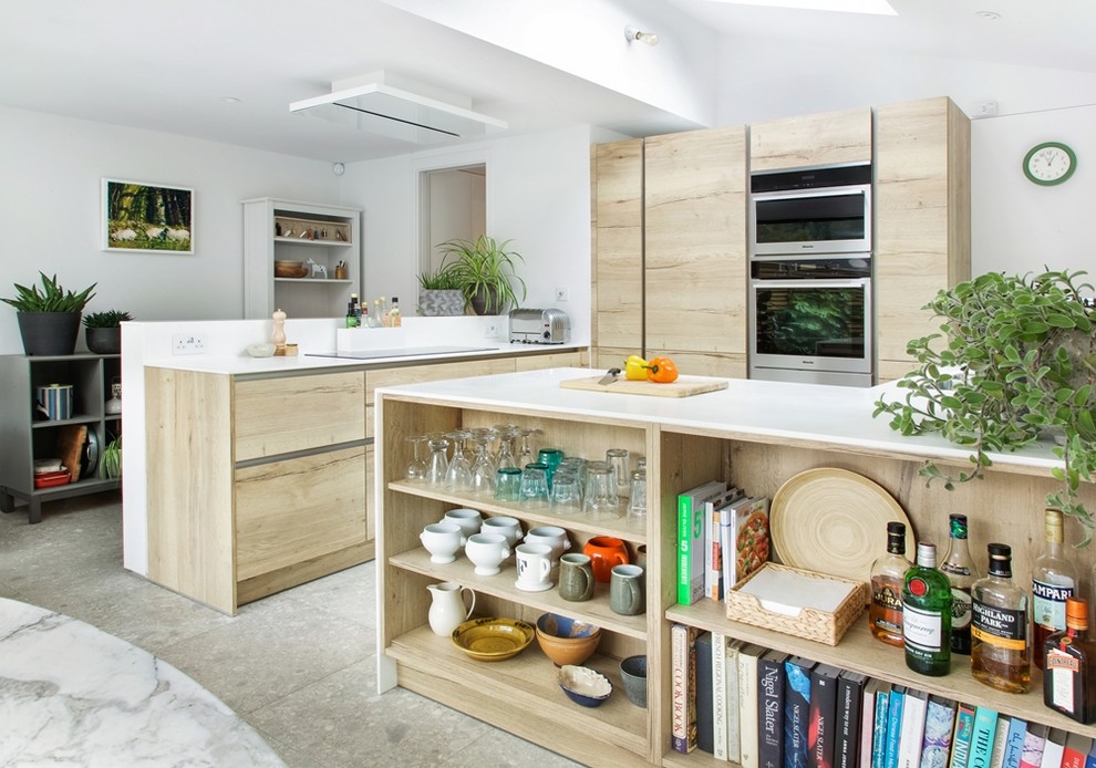 Mid-sized modern l-shaped eat-in kitchen in London with an integrated sink, flat-panel cabinets, light wood cabinets, solid surface benchtops, white splashback, window splashback, stainless steel appliances, concrete floors, no island and grey floor.