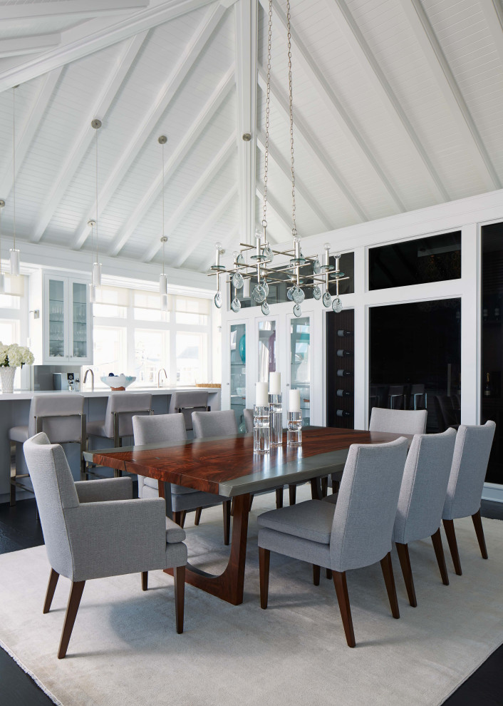 This is an example of a beach style dining room in Other with white walls, dark hardwood floors and black floor.