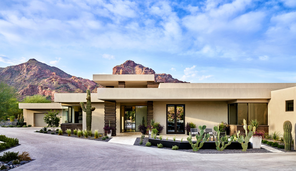 Photo of a large two-storey stucco beige house exterior in Phoenix with a flat roof.