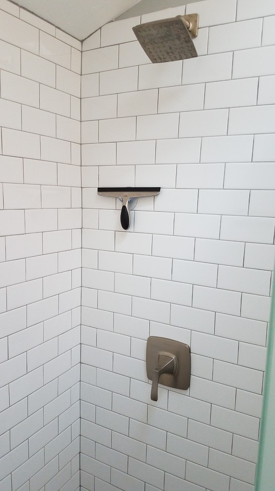Photo of a small transitional bathroom in Boston with furniture-like cabinets, white cabinets, an open shower, white tile, subway tile, blue walls, vinyl floors, an undermount sink and engineered quartz benchtops.