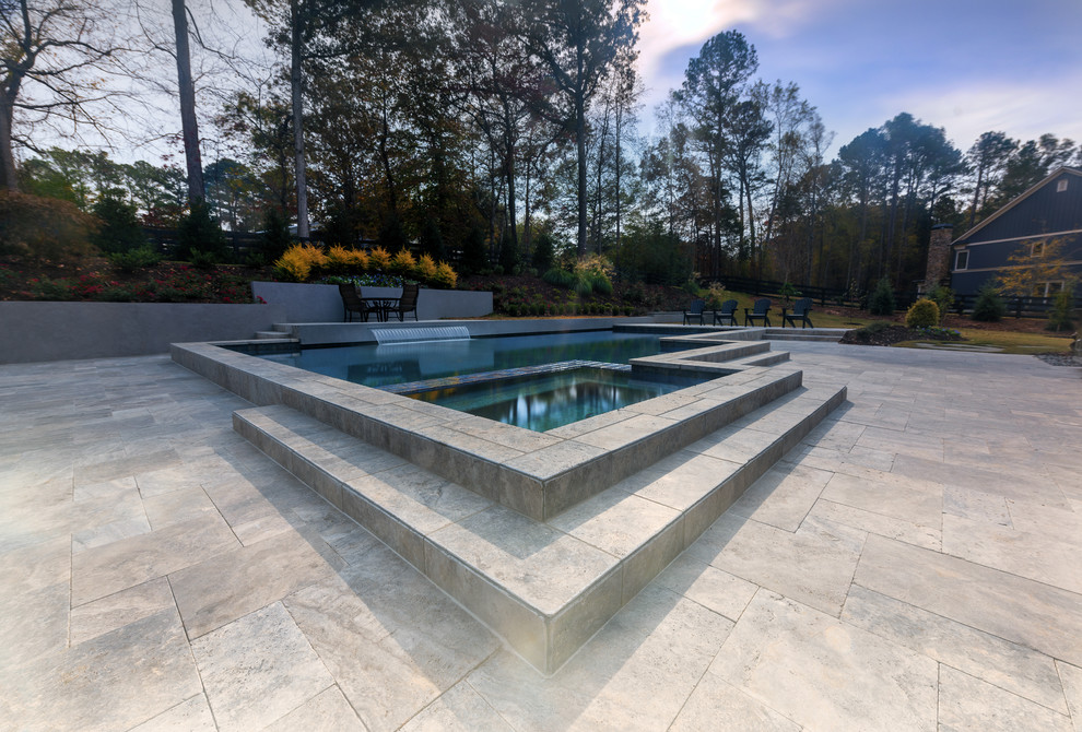 Mid-sized contemporary backyard custom-shaped pool in Atlanta with a water feature and natural stone pavers.