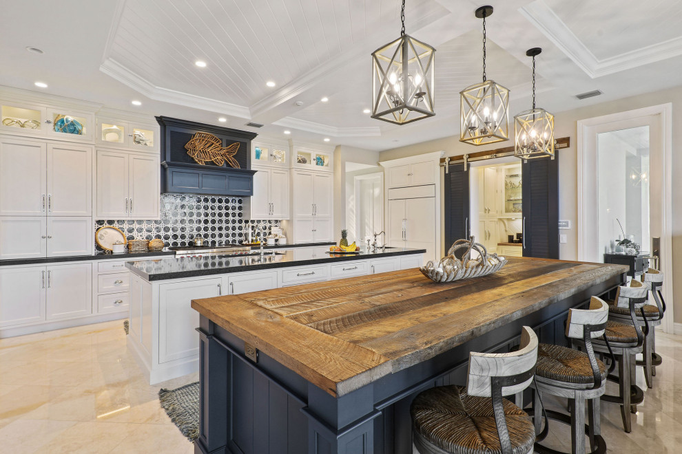 Inspiration for a large transitional l-shaped kitchen pantry in Other with an undermount sink, beaded inset cabinets, white cabinets, wood benchtops, blue splashback, marble splashback, panelled appliances, travertine floors, multiple islands, beige floor and brown benchtop.