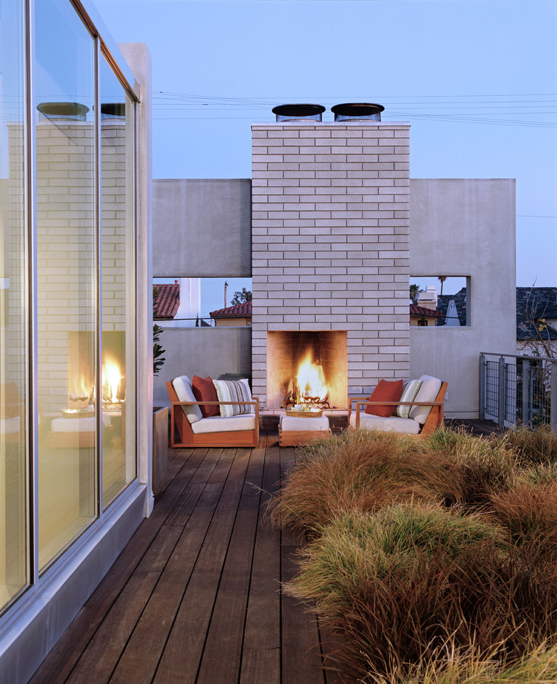 This is an example of a large modern rooftop and rooftop deck in Los Angeles with a fire feature and no cover.