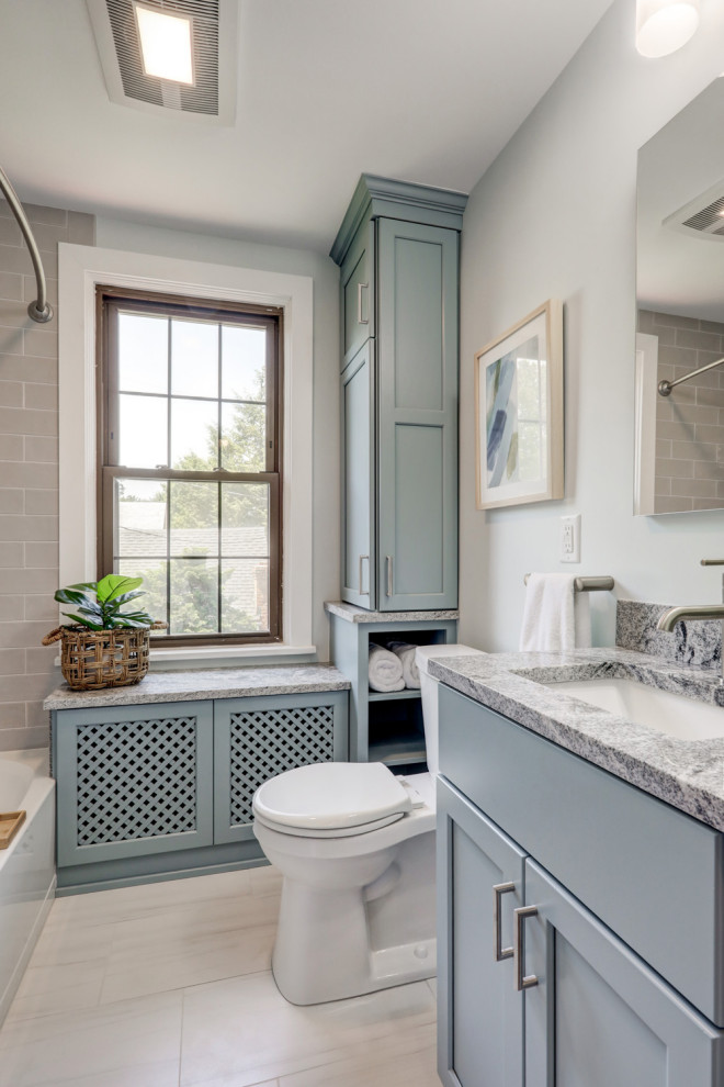 Inspiration for a small transitional master bathroom in Other with recessed-panel cabinets, blue cabinets, a shower/bathtub combo, a two-piece toilet, gray tile, grey walls, ceramic floors, an undermount sink, granite benchtops, a shower curtain, grey benchtops, a single vanity and a built-in vanity.