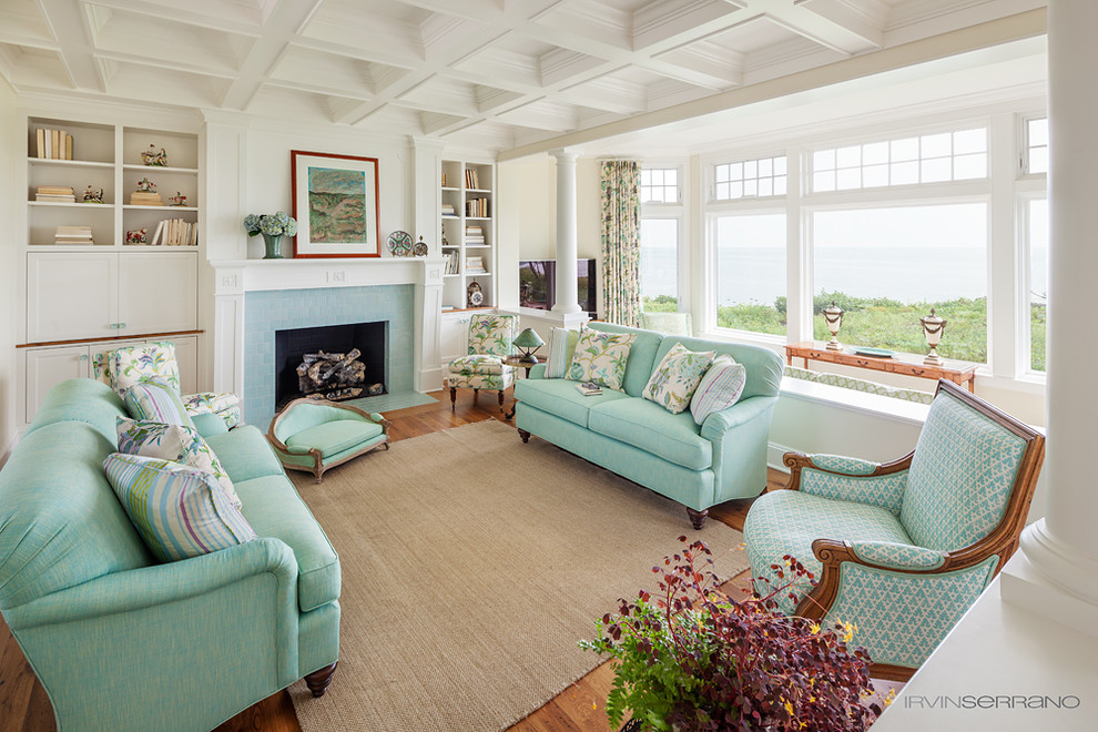 Large beach style formal open concept living room in Portland Maine with white walls, medium hardwood floors, a standard fireplace, a tile fireplace surround and a concealed tv.