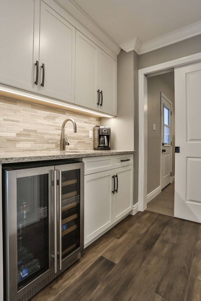 Large transitional medium tone wood floor and gray floor open concept kitchen photo in Toronto with an undermount sink, shaker cabinets, white cabinets, quartz countertops, gray backsplash, marble backsplash, stainless steel appliances, an island and multicolored countertops