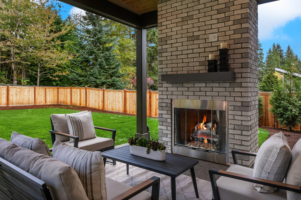 Inspiration for a traditional back patio in Seattle with a fireplace, concrete slabs and a roof extension.