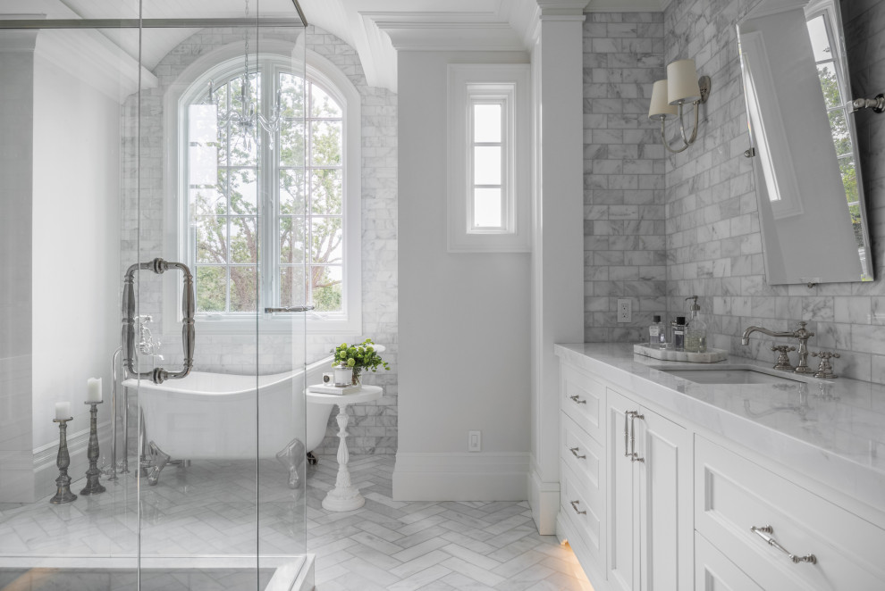 Photo of a small traditional bathroom in Other with a built-in vanity, recessed-panel cabinets, white cabinets, a claw-foot tub, gray tile, grey walls, an undermount sink, grey floor and white benchtops.