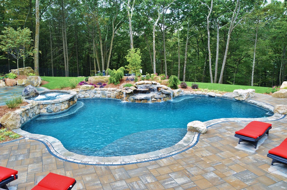 Photo of a large traditional backyard custom-shaped natural pool in Bridgeport with a hot tub and concrete pavers.