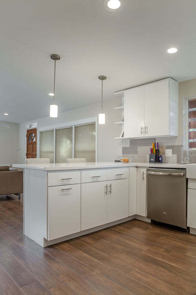 Example of a transitional u-shaped porcelain tile open concept kitchen design in Phoenix with a farmhouse sink, shaker cabinets, white cabinets, quartz countertops, multicolored backsplash, porcelain backsplash, stainless steel appliances and an island