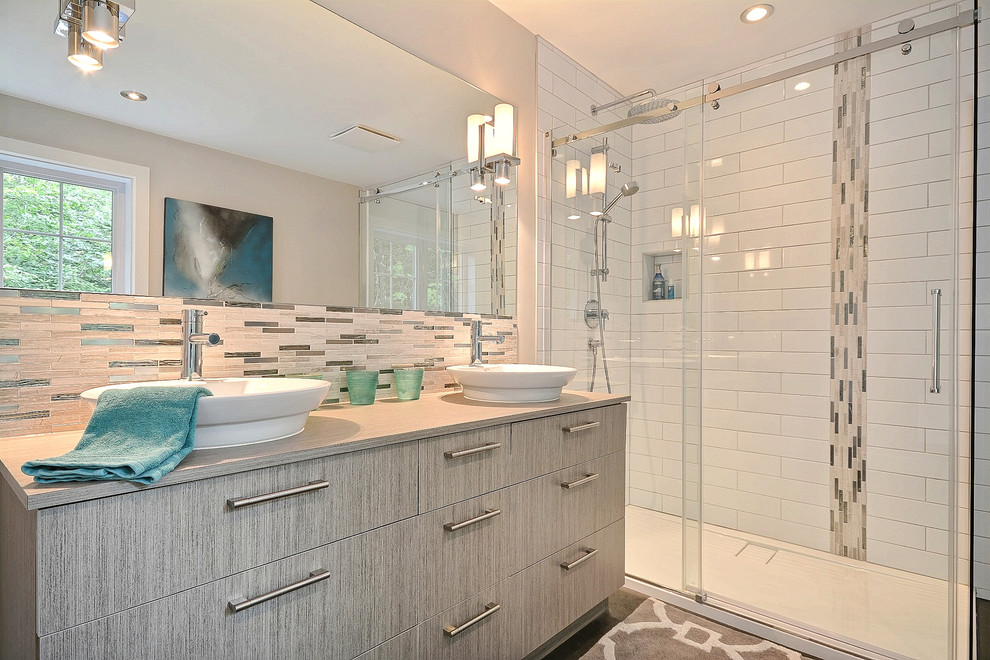 Large contemporary master bathroom in Montreal with flat-panel cabinets, grey cabinets, a freestanding tub, a corner shower, a one-piece toilet, gray tile, stone tile, white walls, slate floors, a vessel sink and laminate benchtops.
