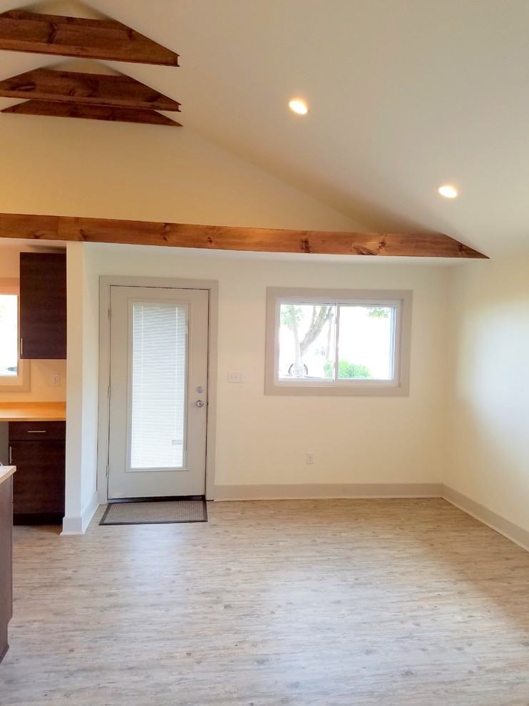 This is an example of a small traditional formal open concept living room in Other with vinyl floors, beige walls, no fireplace and no tv.