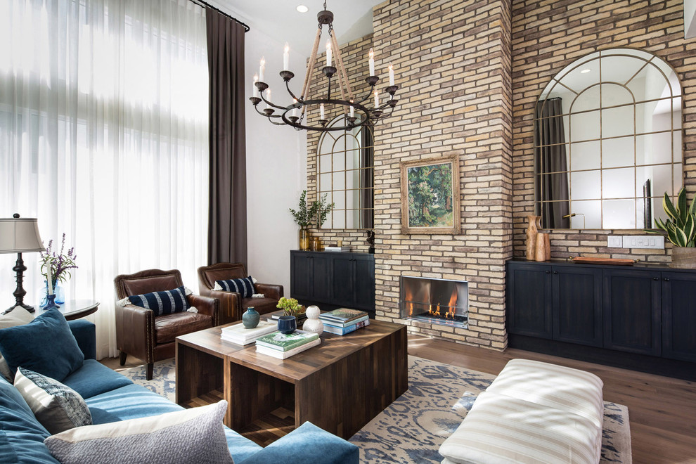 Photo of a mid-sized country formal open concept living room in Los Angeles with beige walls, medium hardwood floors, a standard fireplace, a brick fireplace surround and a wall-mounted tv.