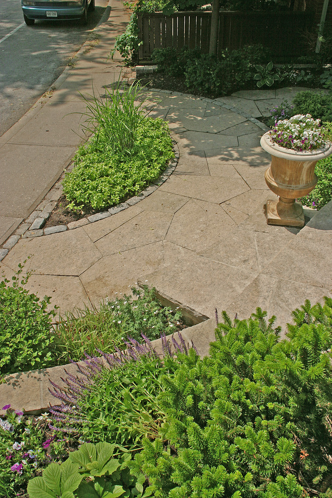Photo of a small transitional front yard partial sun garden for summer in Toronto with a garden path and natural stone pavers.