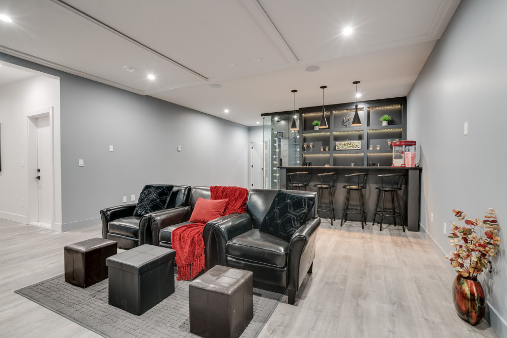 Mid-sized contemporary open concept home theatre in Vancouver with a projector screen, grey walls, laminate floors and grey floor.